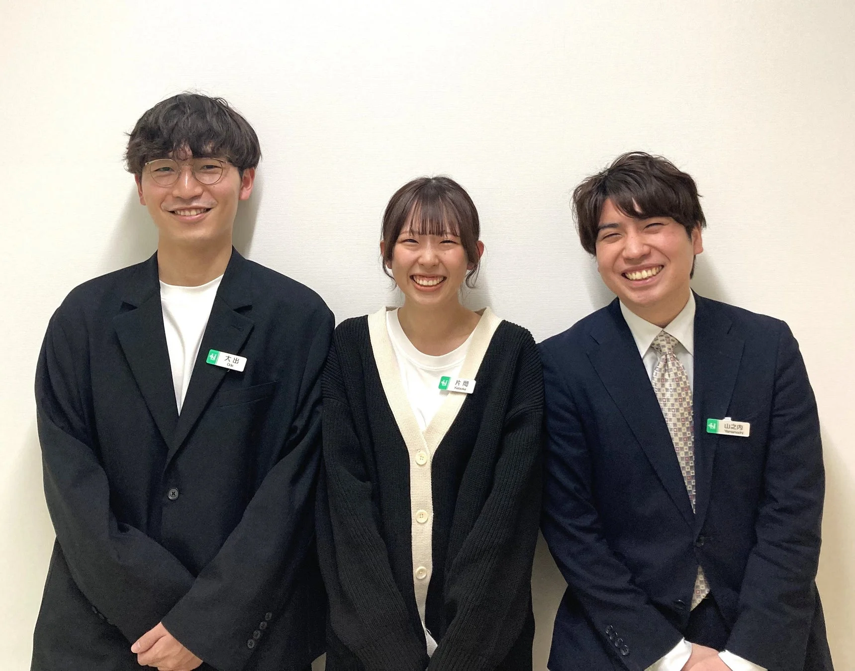 笑顔を見せる3人の男女が写った集合写真