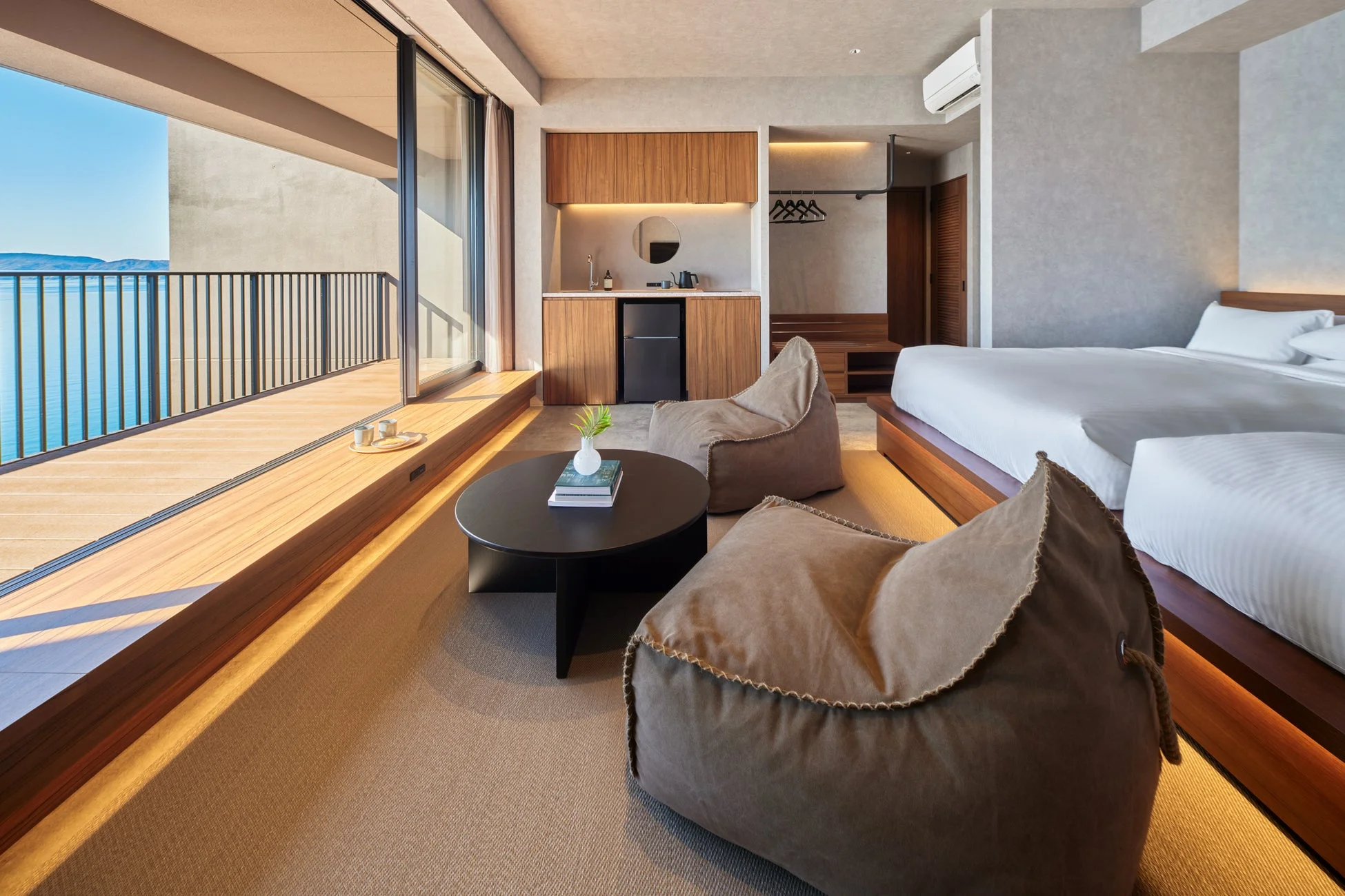 海を見下ろすバルコニー付きのモダンでミニマリストなホテル客室