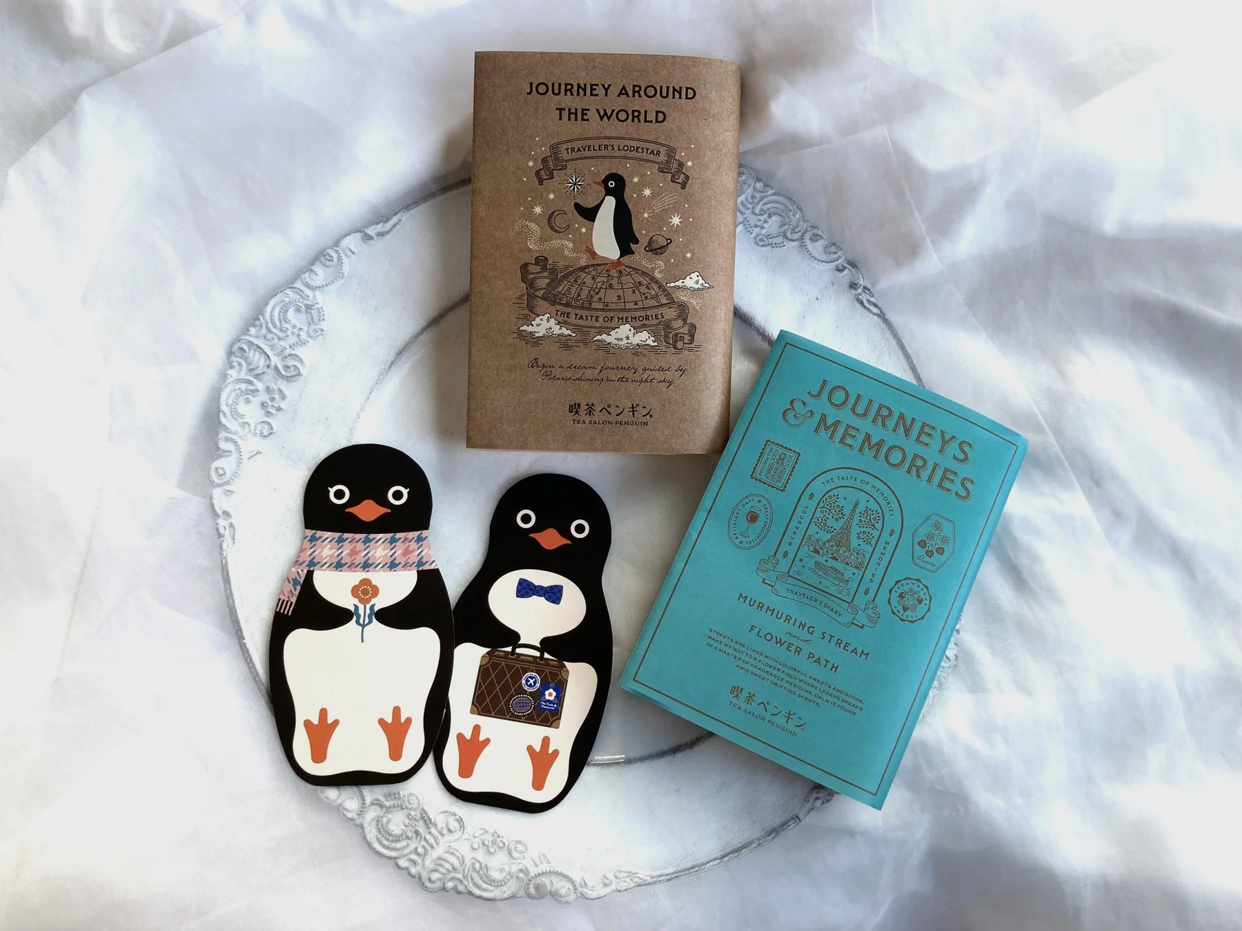 ペンギンのイラストが描かれた旅をテーマにしたノートとペンギン型の雑貨