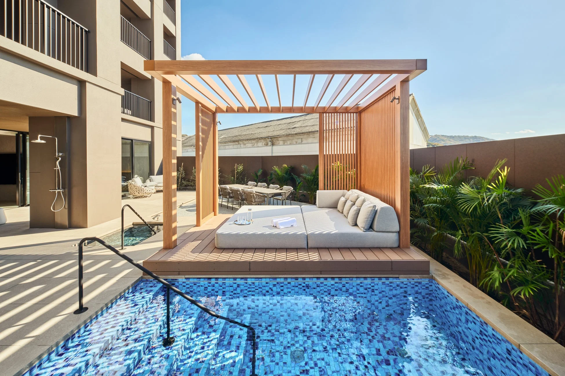 青いタイルが美しいプールと、木製のパーゴラ