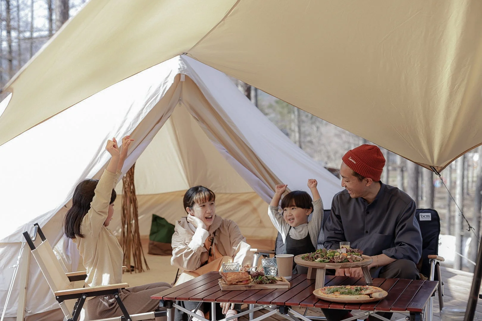 家族がキャンプ場で食事を楽しんでいる様子