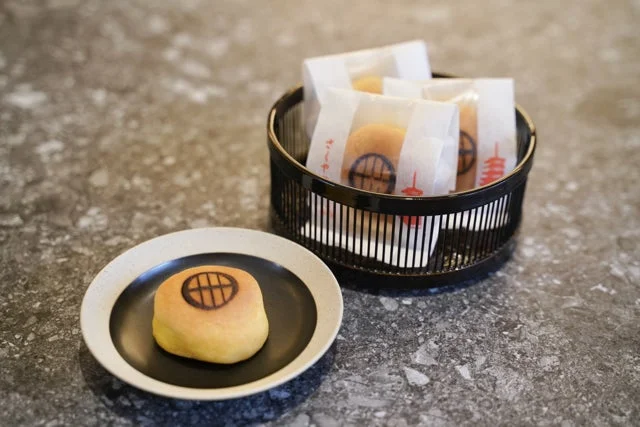 お皿に置かれた一つと、籠に複数個入った個包装の和菓子が写っています。きみしぐれというお菓子で、京都のお土産のようです。上品な雰囲気の伝統的な和菓子です。