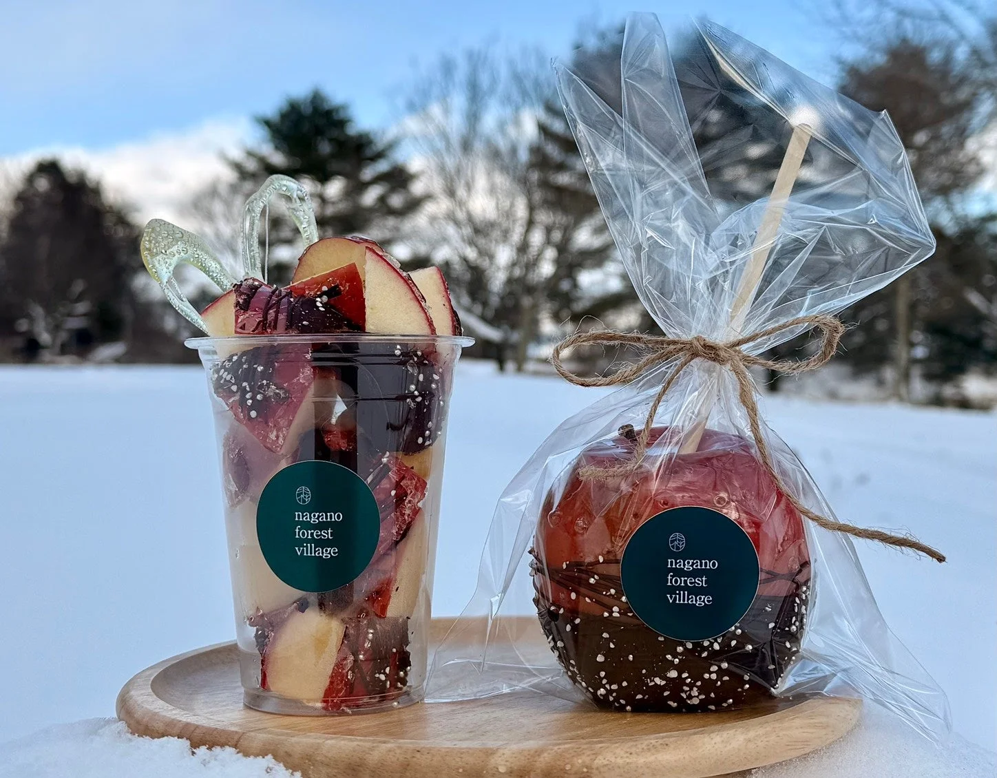 雪景色の中で、木のトレイに置かれたりんごスイーツ