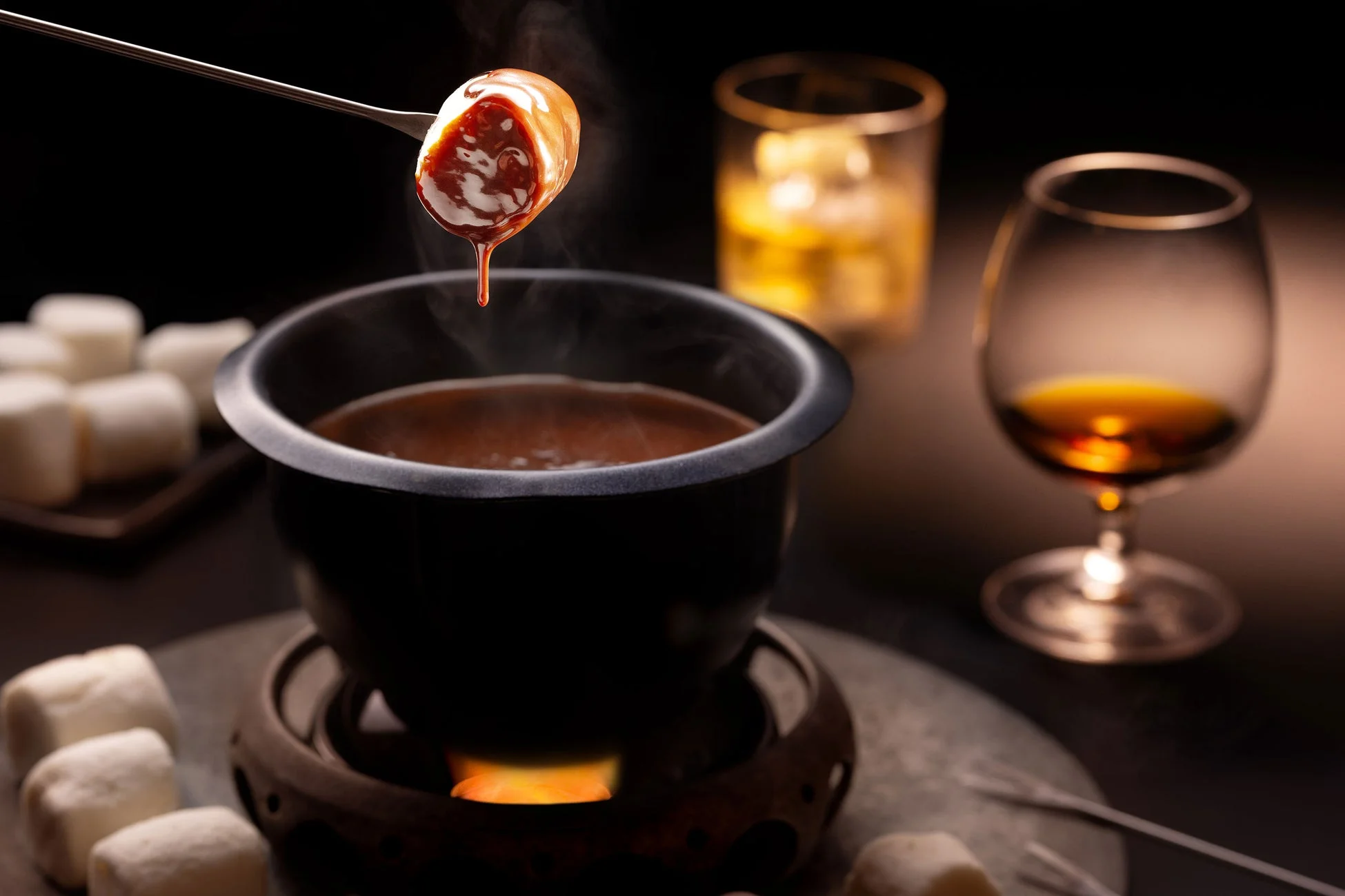 温かいチョコレートフォンデュにマシュマロを浸している様子