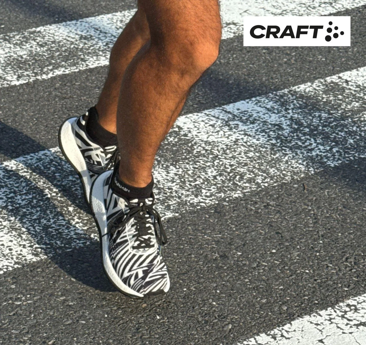 横断歩道を走る人の足元をクローズアップしたゼブラ柄のランニングシューズ
