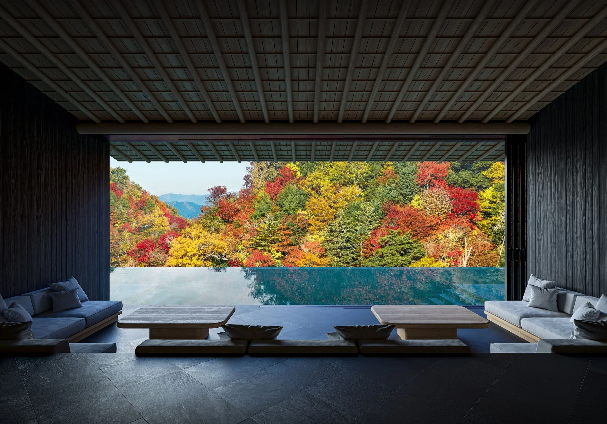 鮮やかな紅葉の森を望む、モダンなインテリアの部屋とインフィニティプールが一体となった絶景の空間。