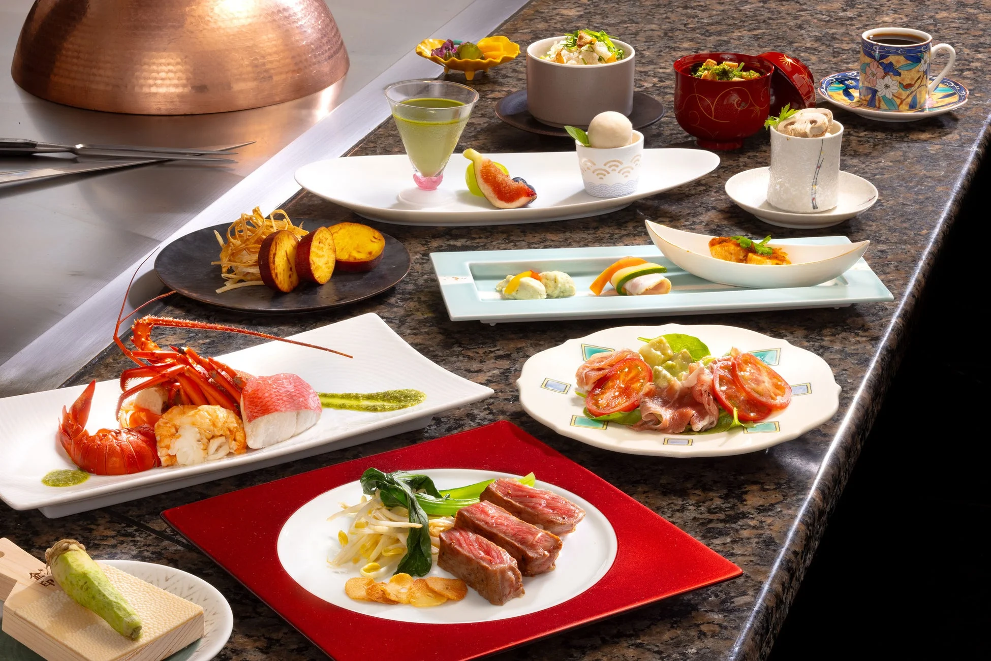 鉄板焼きカウンターに並べられた豪華なコース料理