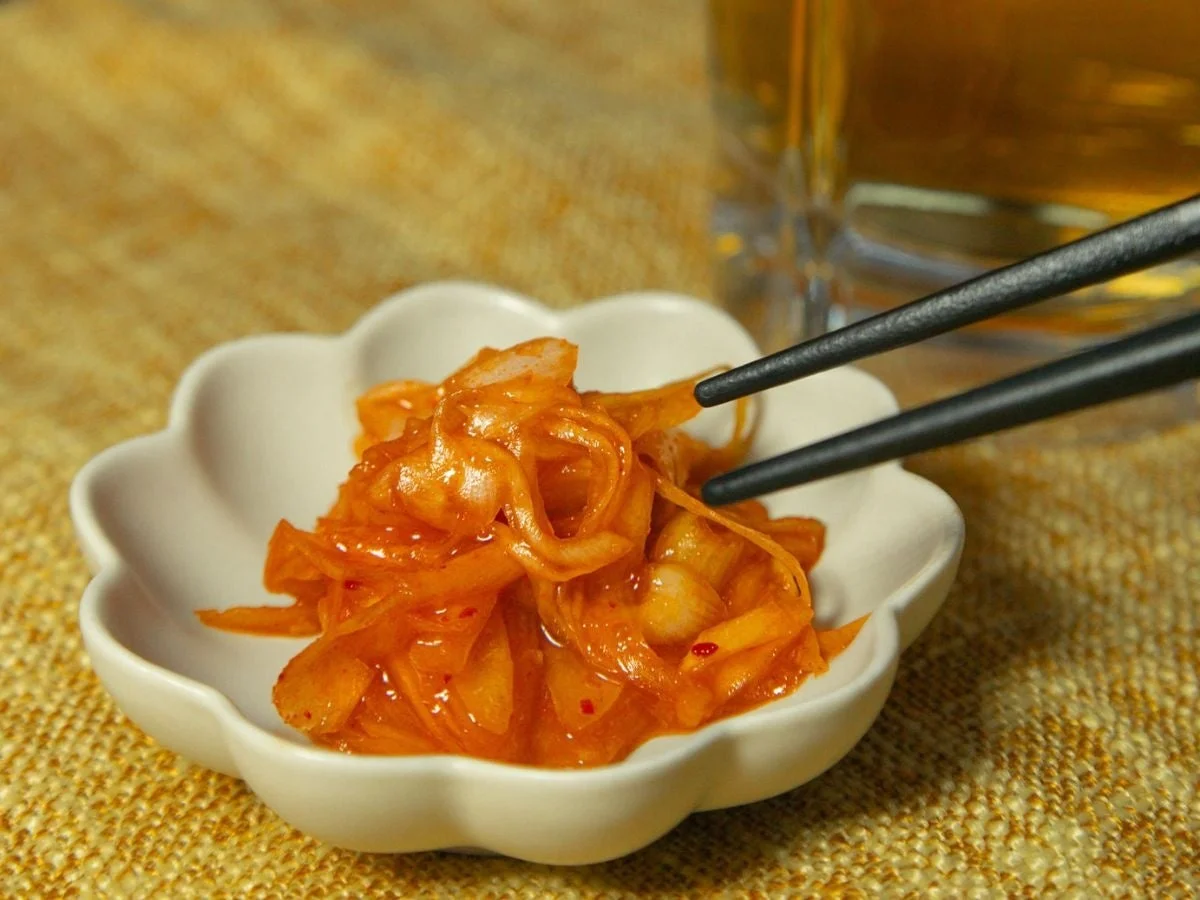 白い小鉢に盛られた、辛そうな玉ねぎの漬物