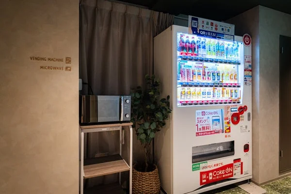 飲料の自動販売機と電子レンジが設置されたアメニティスペース