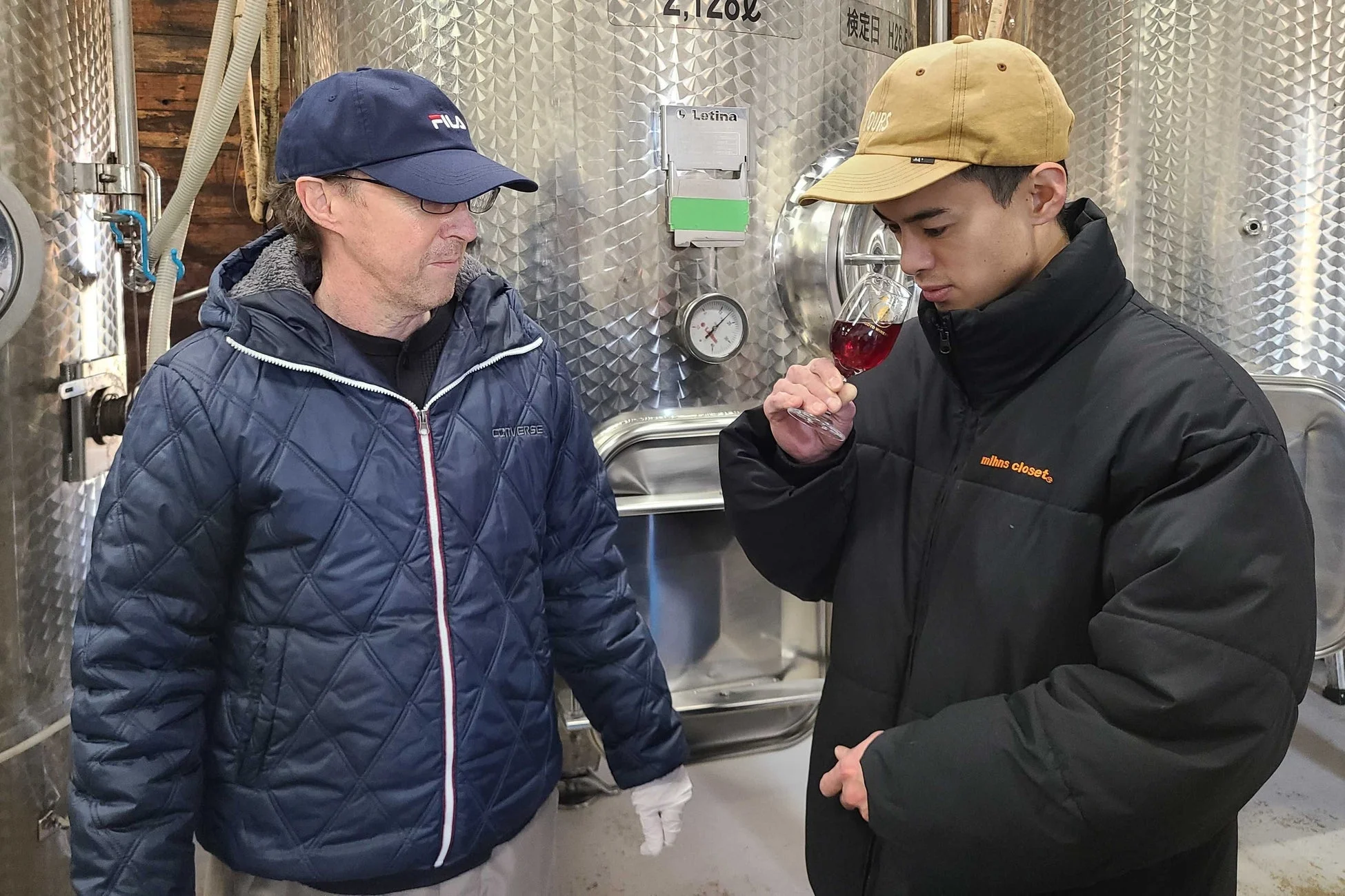 ワイナリーでワインを試飲する男性たち