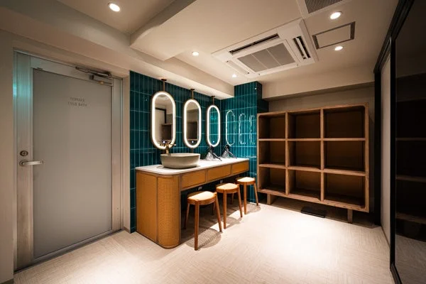 緑のタイル壁が特徴的なモダンな洗面所兼脱衣室