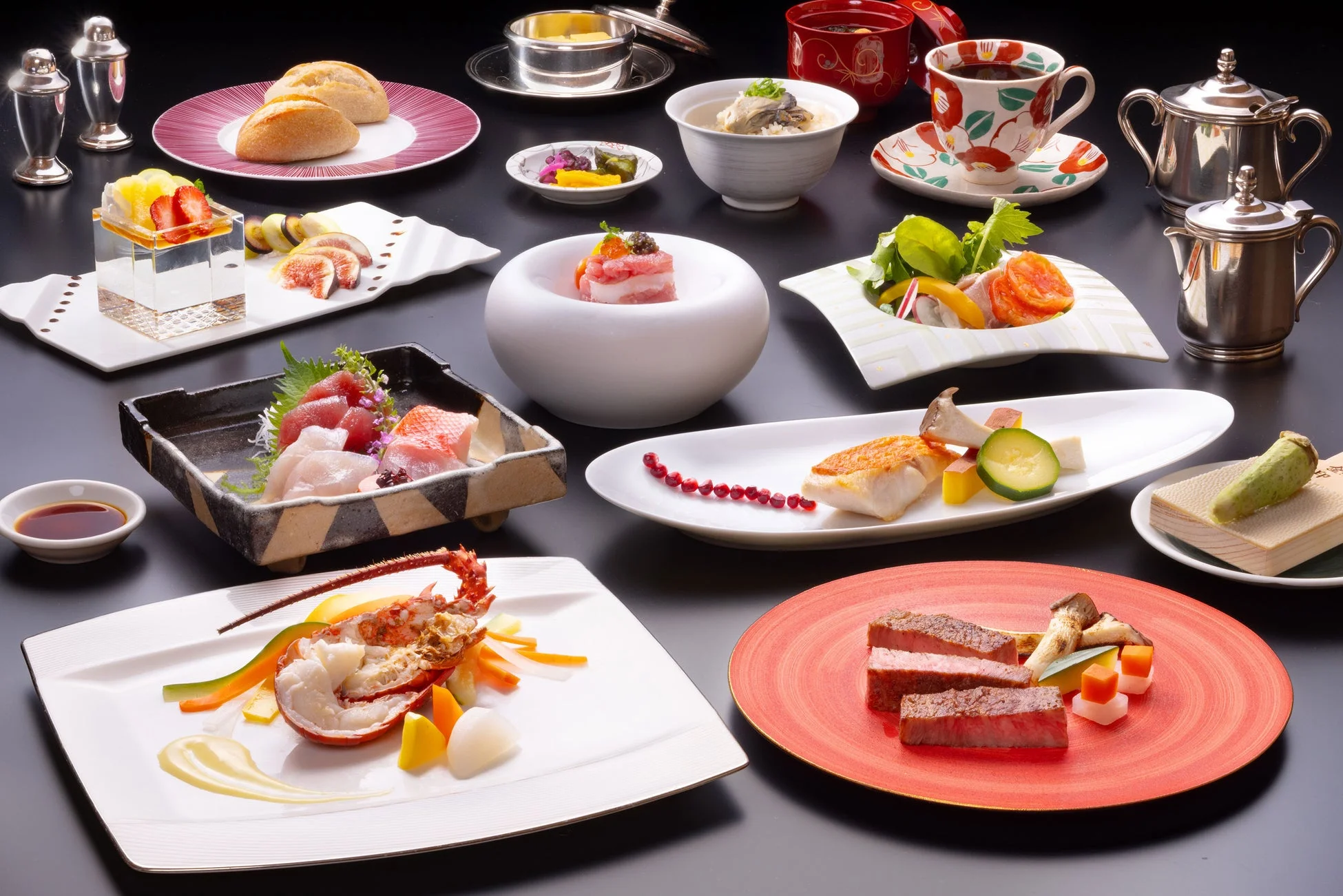 黒いテーブルに並べられた豪華なフルコース料理