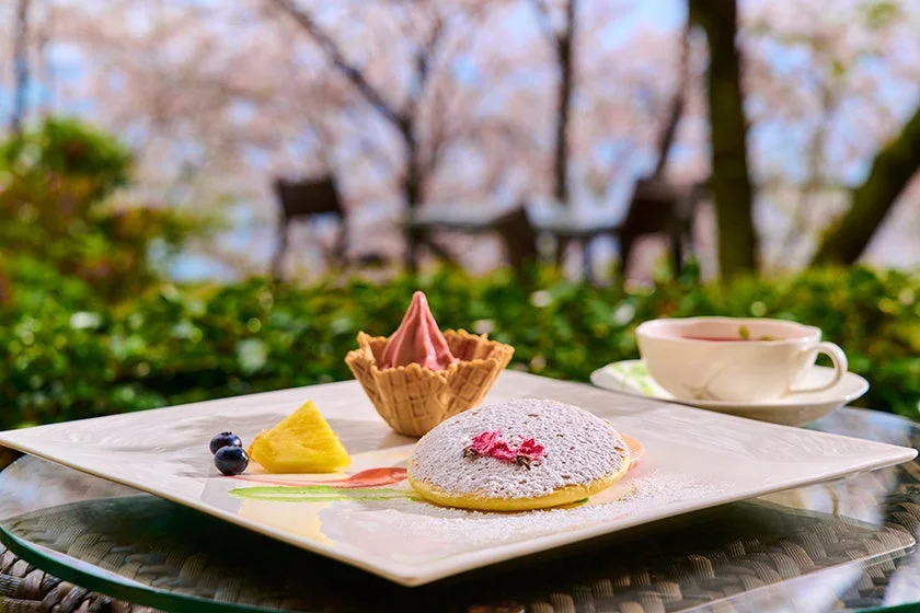 桜が咲き誇るテラス席で提供される桜パンケーキ