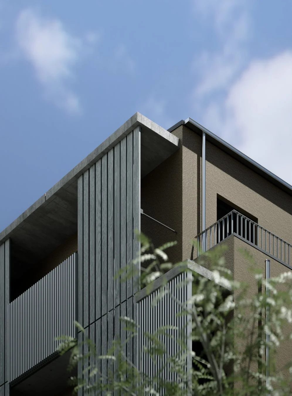 現代的なデザインの建物の外観を捉えた画像です。ベージュ色の壁とコンクリート、縦のスラットが特徴的で、青空を背景に、手前には緑の植栽が写り込んでいます。