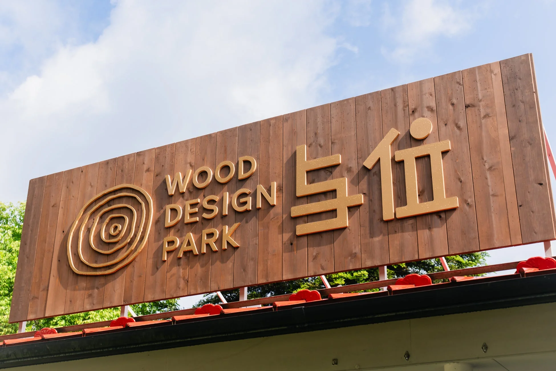 青空の下に設置された「WOOD DESIGN PARK 与伍」と書かれた木製の看板